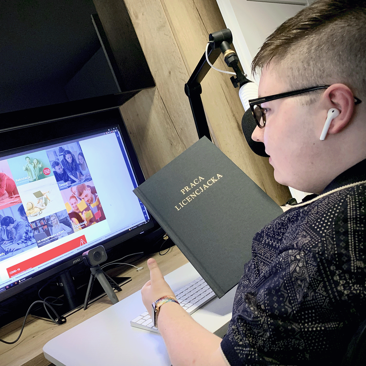 Kamil Tunkiewicz przy komputerze po obronie pracy licencjackiej na AHE w Łodzi